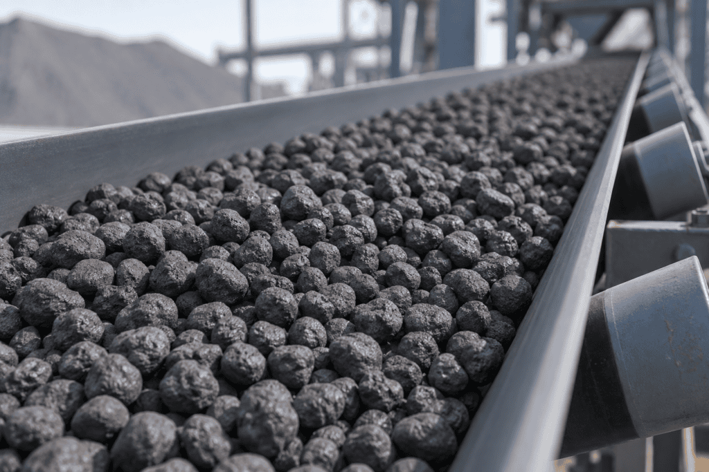 Illustrative iron pellets on an industrial conveyor